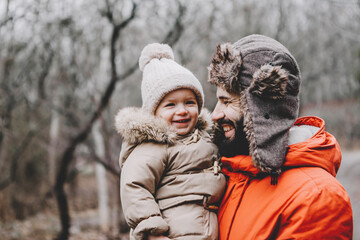 Handsome young dad and his little sweet daughter have fun outdoors in winter. Happy family spending time together. Family concept.