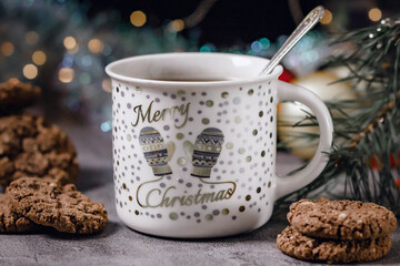 In a protein mug/Cup of tea/coffee. The mug stands under the tree, with a gold design, mittens and the words 