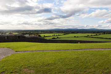 ROCK OF CASHEL, COUNTY TIPPERARY, IRELAND - SEPTEMBER 12, 2018: Green field viewed from Rock of Cashel, also known as Cashel of the Kings and St. Patrick's Rock. Cloudy but sunny sky.