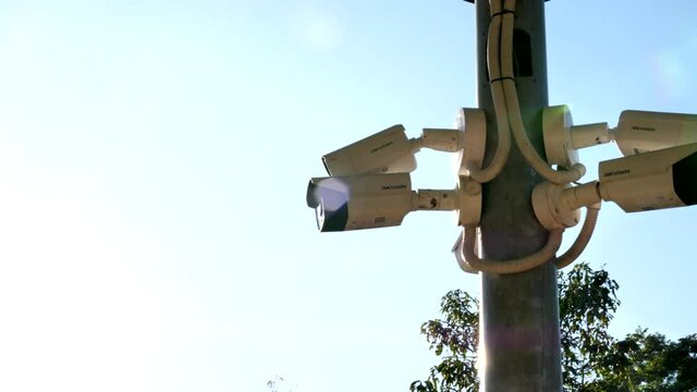 wide shot of security cameras on a post from left side
