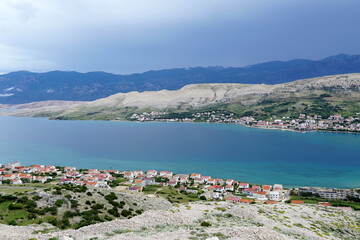 Turquoise sea surface in bay in front of the town of Pag on the Croatian island of Pag on a cloudy day