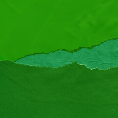 Green torn paper collage close-up. Texture made from various paper and cardboard parts. Damaged old...