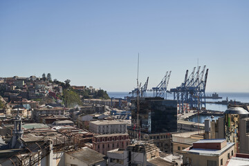 view on the sub urban city scape of valparaiso in chile with the port in the background and tall cranes_1