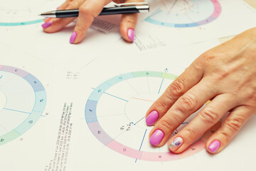 Workplace of a modern astrologer. Printouts of astrological charts, charts, tables, diagrams lying...