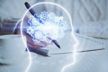 Multi exposure of writing hand on background with brain hologram. Concept of learning.