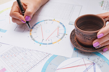 Workplace of a modern astrologer. Printouts of astrological charts, charts, tables, diagrams lying...