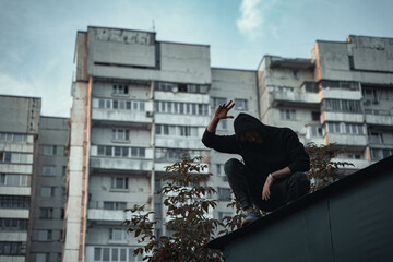 
the man in black is sitting on the roof - obrazy, fototapety, plakaty