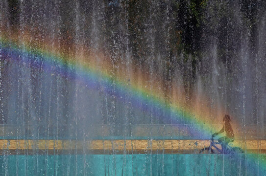 Rosd to happiness. A child rides a bicycle to a rainbow.