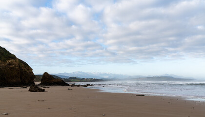 Fototapeta premium view of wild and rocky and sandy beach at low tide