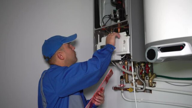 Technician inspector inspecting maintenance gas boiler heating system