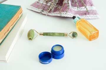 Beauty face care massage with jade facial rollers for spa skin care treatment at home.
