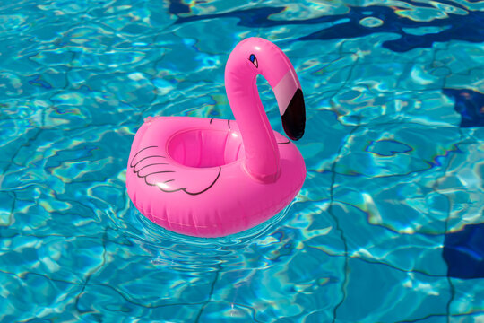 Summer fun. Pink inflatable flamingo in pool water for summer beach background. Luxury lifestyle travel.