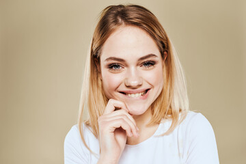 Cheerful blonde gesturing with her hands studio beige background