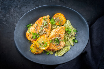 Modern style traditionelles italienisches Hühnchen Piccata mit Kapern und Nudeln angeboten als Draufsicht in einem Design Teller mit Textfreiraum