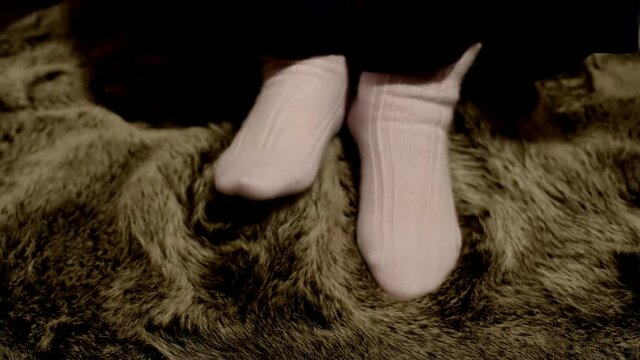 Frau in Angora Socken genie&szlig;t und streichelt sich in einem Schafsfell  
