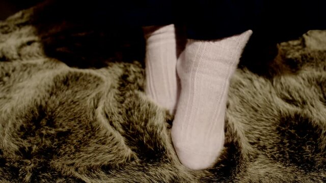 Frau in Angora Socken genie&szlig;t und streichelt sich in einem Schafsfell  