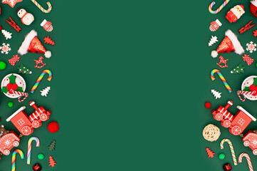 Christmas or New Year green background with red toys borders. Traditional and retro toys in the corners. Bells, lollipop canes, snowflakes, steam locomotive, Christmas trees and Santa hat.