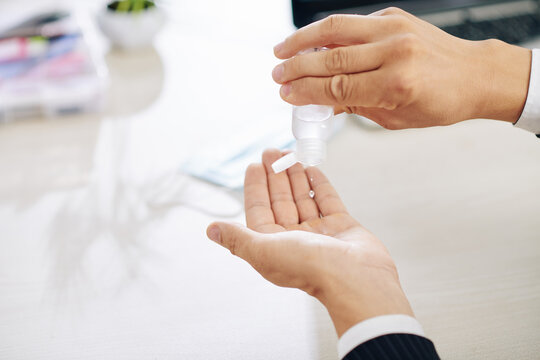 Close-up image of businessman applying hand sanitizer to clean and disinfect hands