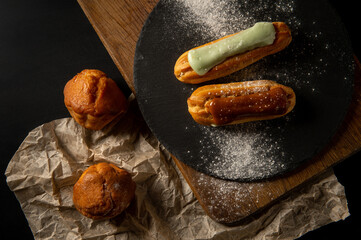 Eclairs. Cupcakes. Eclairs and cupcakes are on the table. Confectionery. Serving. Decoration.