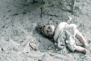 A creepy doll lies on an old abandoned playground