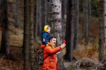 mother and son walk through the forest in autumn