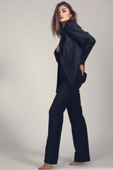 Fashion minimalist portrait of brunette female model on grey background. stylish clothing, black ...