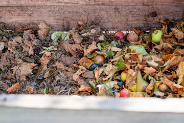 Homemade wooden compost bin in the garden. Recycling organic biodegradable material and household waste in composter. Best organic fertilizer.