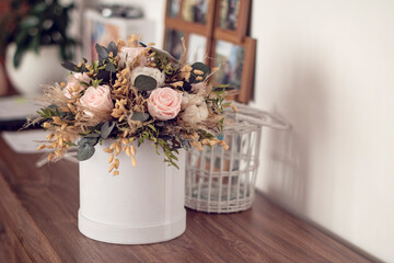 Long lasting flowers decoration. Preserved roses with dried flowers bouquet closeup. Selective...