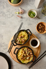 Egg noodles in black bowls, asian food, top view