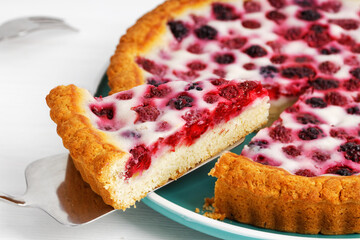 Closeup homemade berry pie with raspberry and blackberry on white wooden table. Shallow focus.
