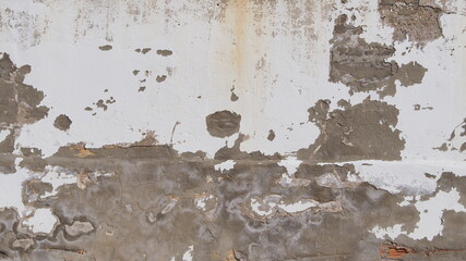 White sun-damaged wall with paint bald spots