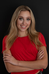 Portrait ofa beautiful young woman in red tshirt over black background