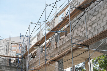 scaffolding of a brick house. reconstruction of a building and facing with new covering. repair and renovation concept. selective focus