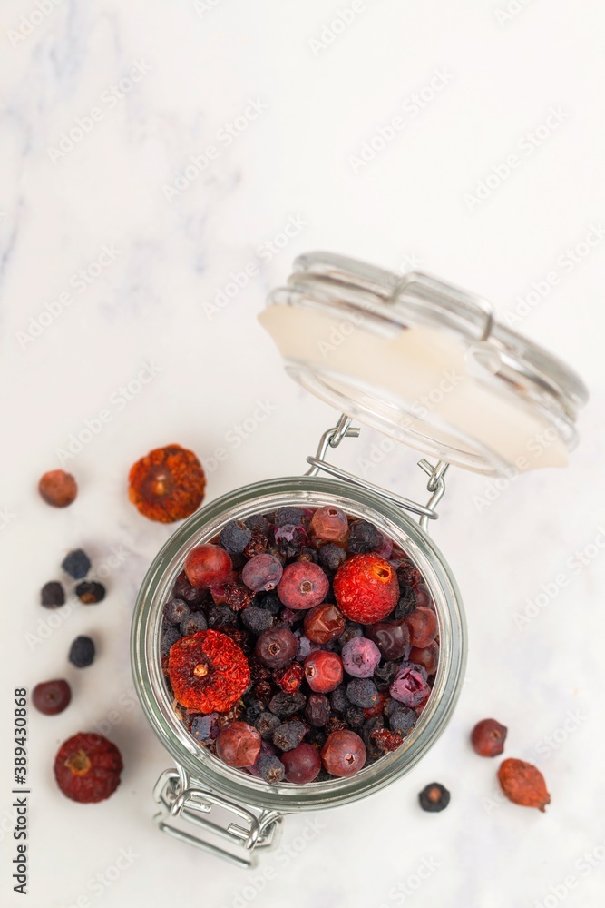 Wall mural Assorted mix of dried berries (rosehip, lingonberry, cowberry, cranberry, black currant, blueberry) for healthy hot drinks. Berry tea. Selective focus, copy space