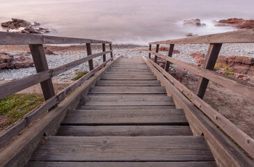 Fototapeta premium ponton menant à une plage de galets et à la mer