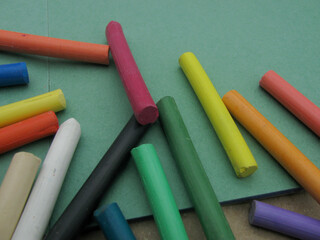 Multi-colored dry pastel on an empty green sheet for drawing