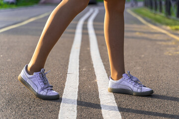 Female legs on a bike path on sunny day