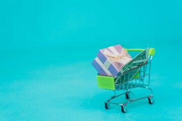 Online shopping concept - trolley cart full of present over blue background. Black Friday and Ciber Mondey