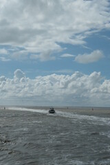 Beautiful cloudy sky at sea with a boat in the distance.