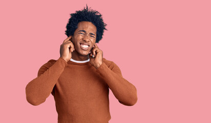 Fototapeta premium Handsome african american man with afro hair wearing casual clothes covering ears with fingers with annoyed expression for the noise of loud music. deaf concept.