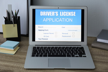 Laptop with driver's license application form on table in office