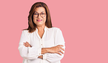 Fototapeta premium Middle age latin woman wearing casual clothes and glasses happy face smiling with crossed arms looking at the camera. positive person.