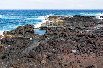 Fototapeta na wymiar Azores, island of Sao Miguel, the natural lava rock pools Caneiros in the village of Mosteiros. 