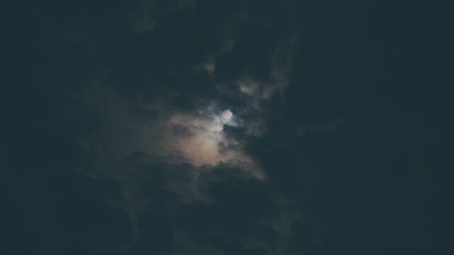 Full moon with moving clouds in the dark blue sky at night in the loy krathong day 4k