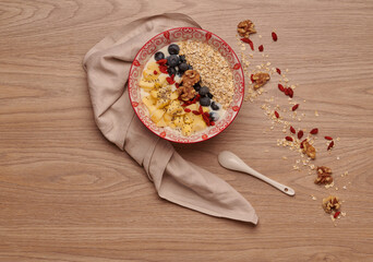 Healthy snacks in bowl: yoghurt, oat flakes, fruit, chia and goji seeds.