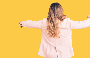 Young caucasian woman wearing business clothes hugging oneself happy and positive from backwards....