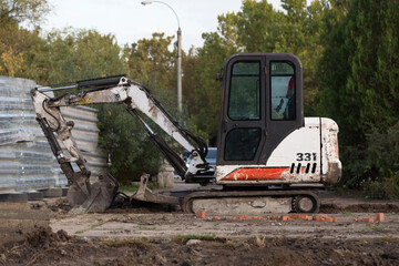Fototapeta na wymiar The excavator digs the ground in the park.