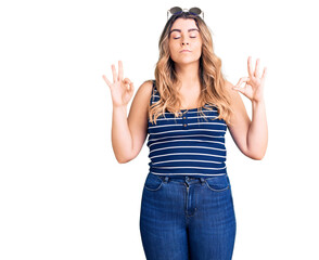 Young caucasian woman wearing casual clothes and sunglasses relax and smiling with eyes closed doing meditation gesture with fingers. yoga concept.