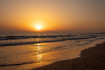 Beautiful Sunset on the Beach with orange sky and yellow sunlight reflection  