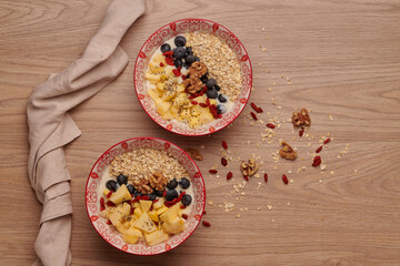 Healthy snacks in bowl: yoghurt, oat flakes, fruit, chia and goji seeds.
